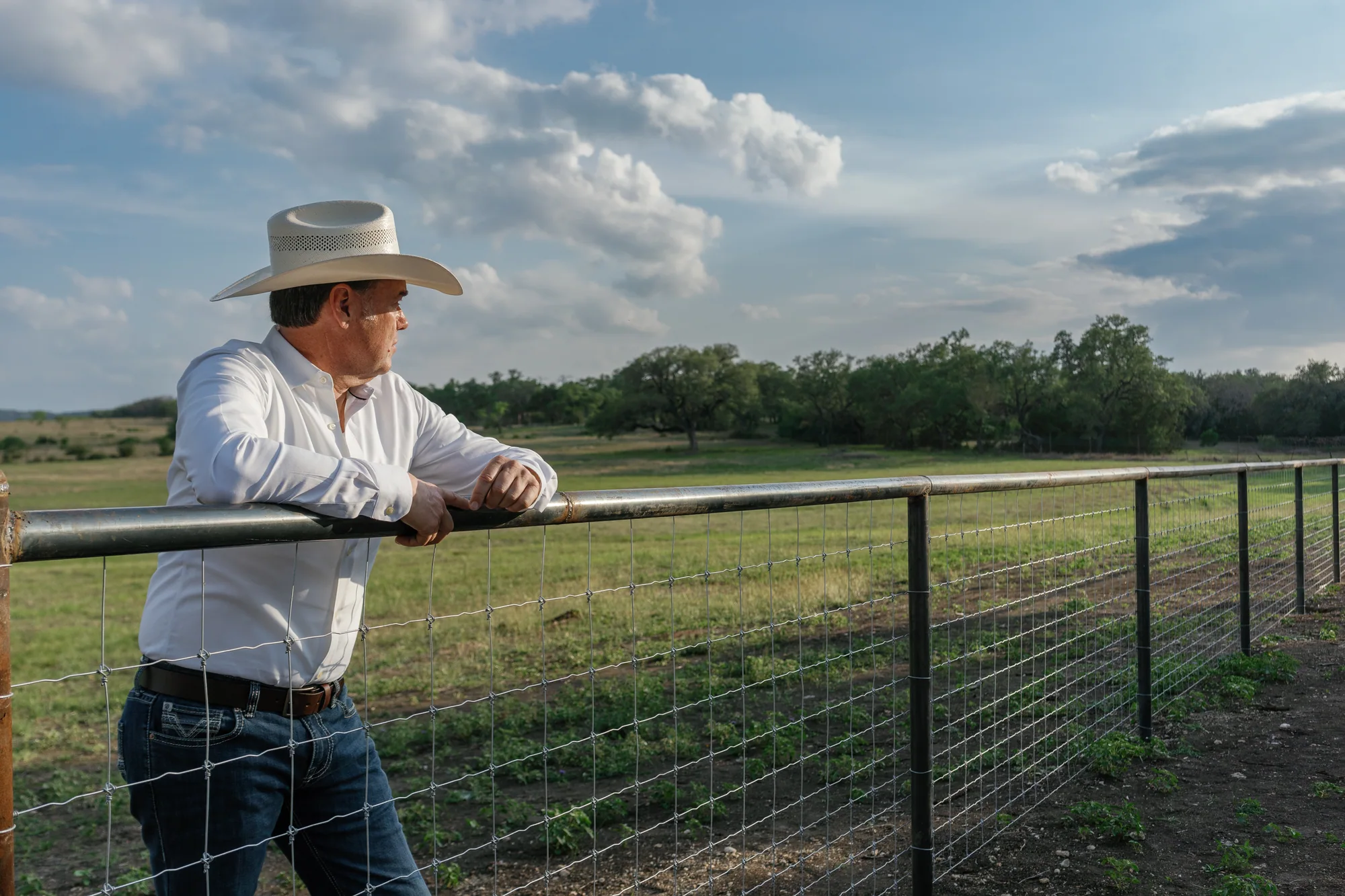Kevin Travis looking across ranch land from a fence
