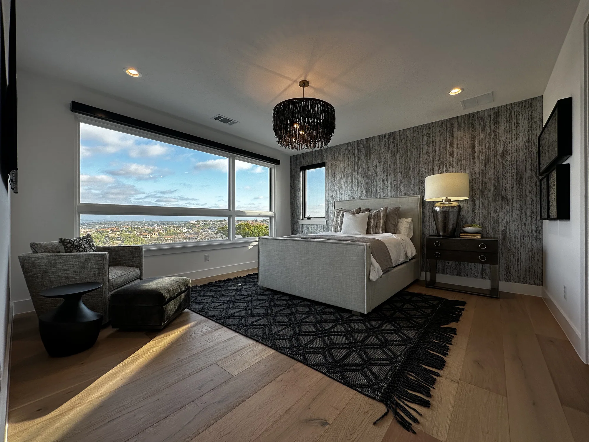 Primary bedroom with textured walls and a panoramic Hill Country view
