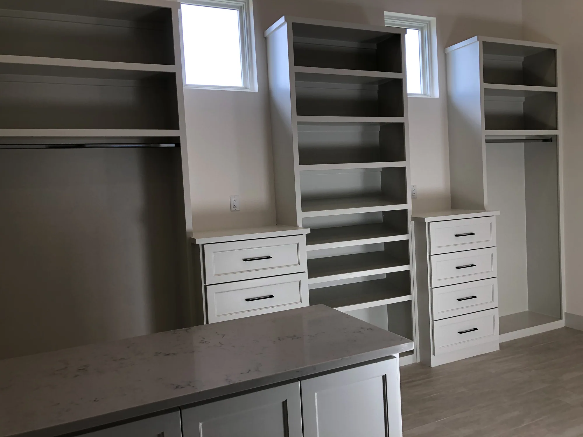 Custom walk-in closet with a central island and fitted shelving