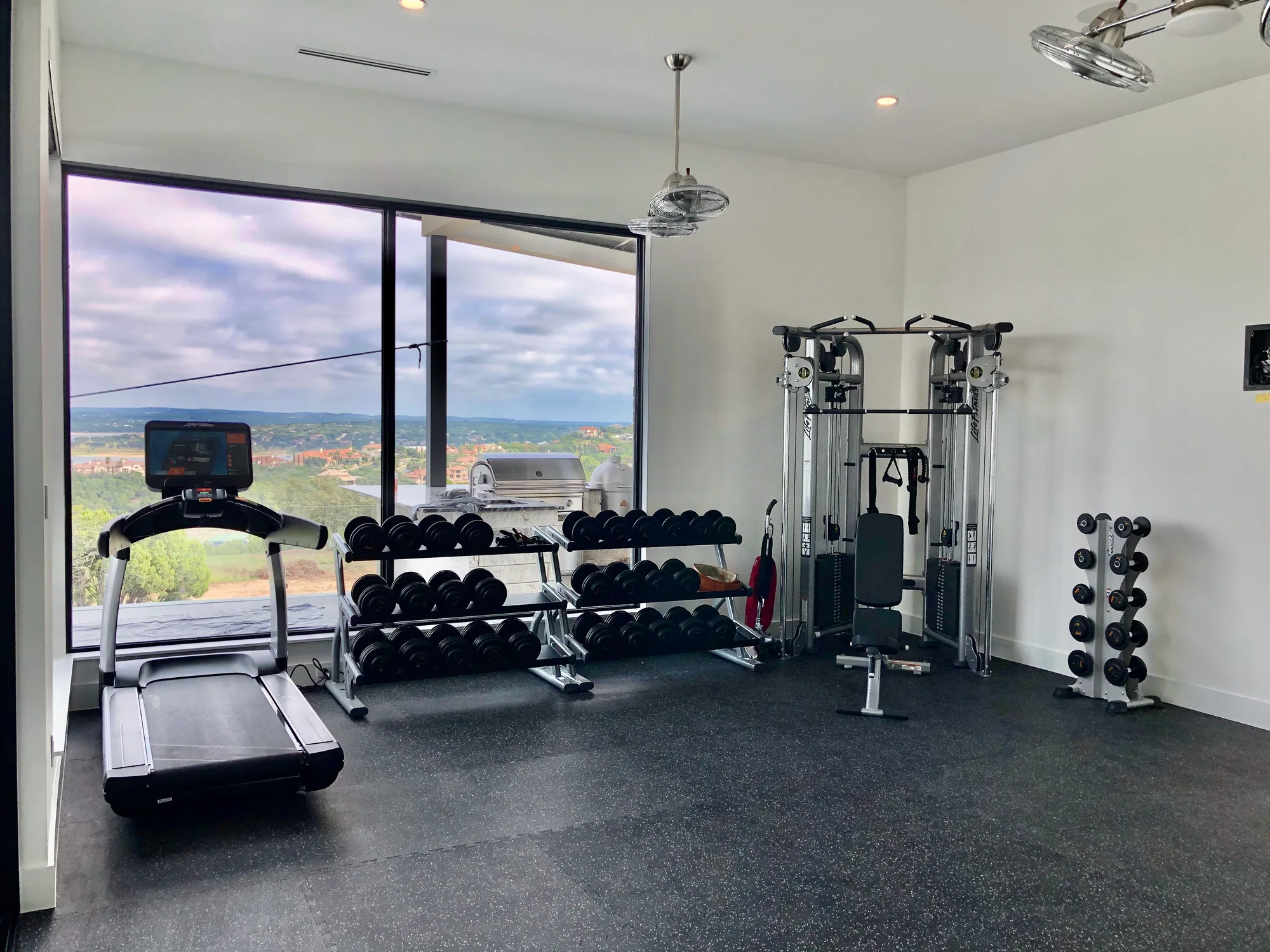 Private home gym with free weights and an expansive lake view