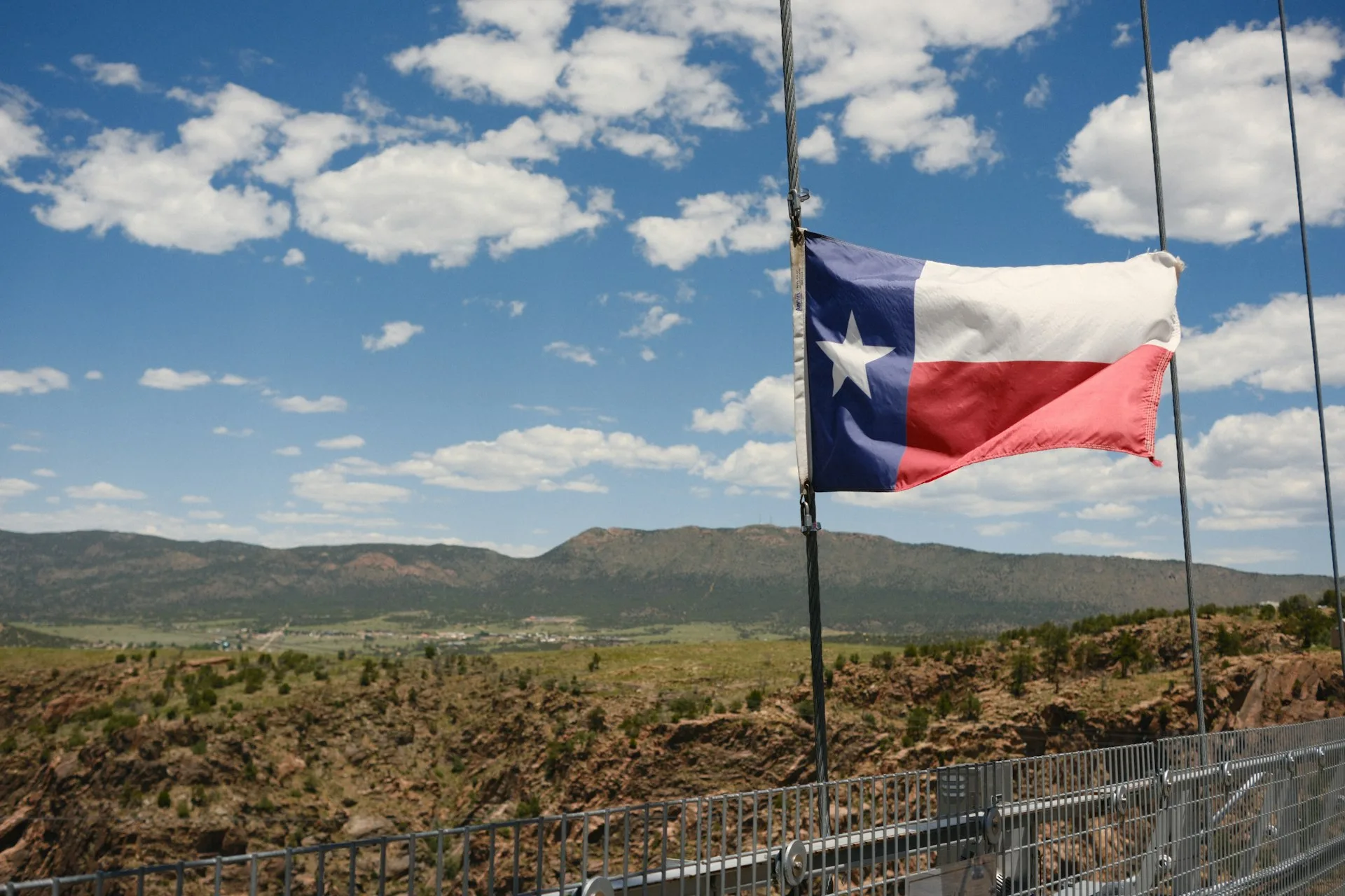 Texas state flag over the Hill Country. Peak Storm Services serves all of Texas