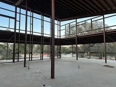 A large building under construction with a lot of windows and a concrete floor.
