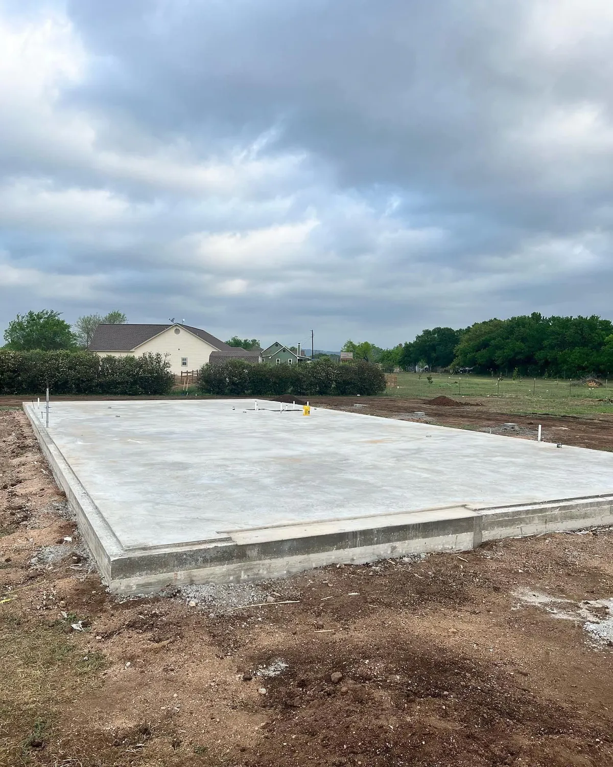 A large concrete slab is sitting in the middle of a dirt field.