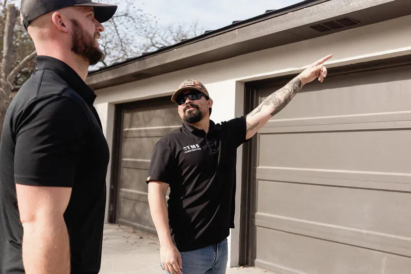 Team members inspecting property roofline